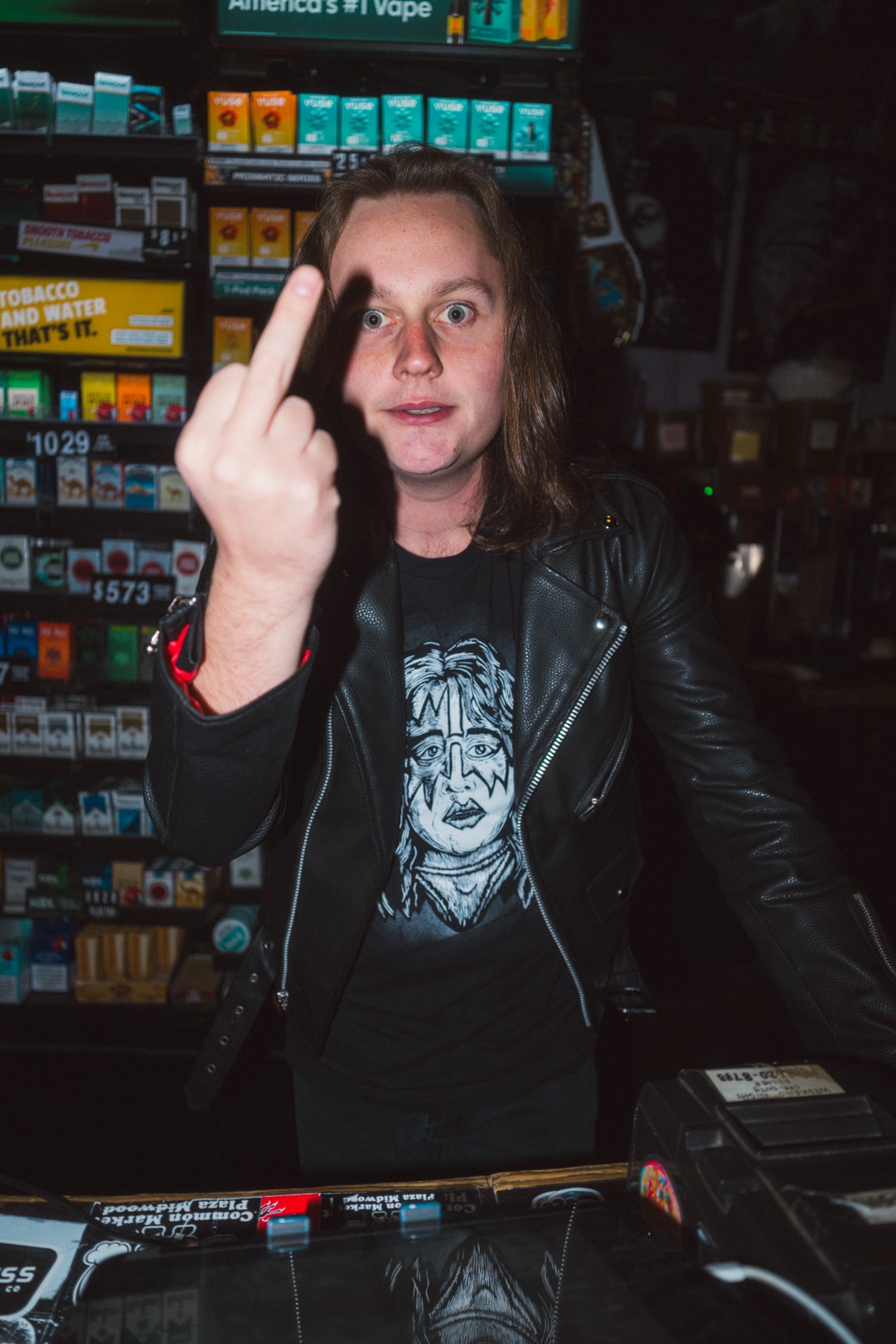 Street portrait, person in a leather jacket at a store counter