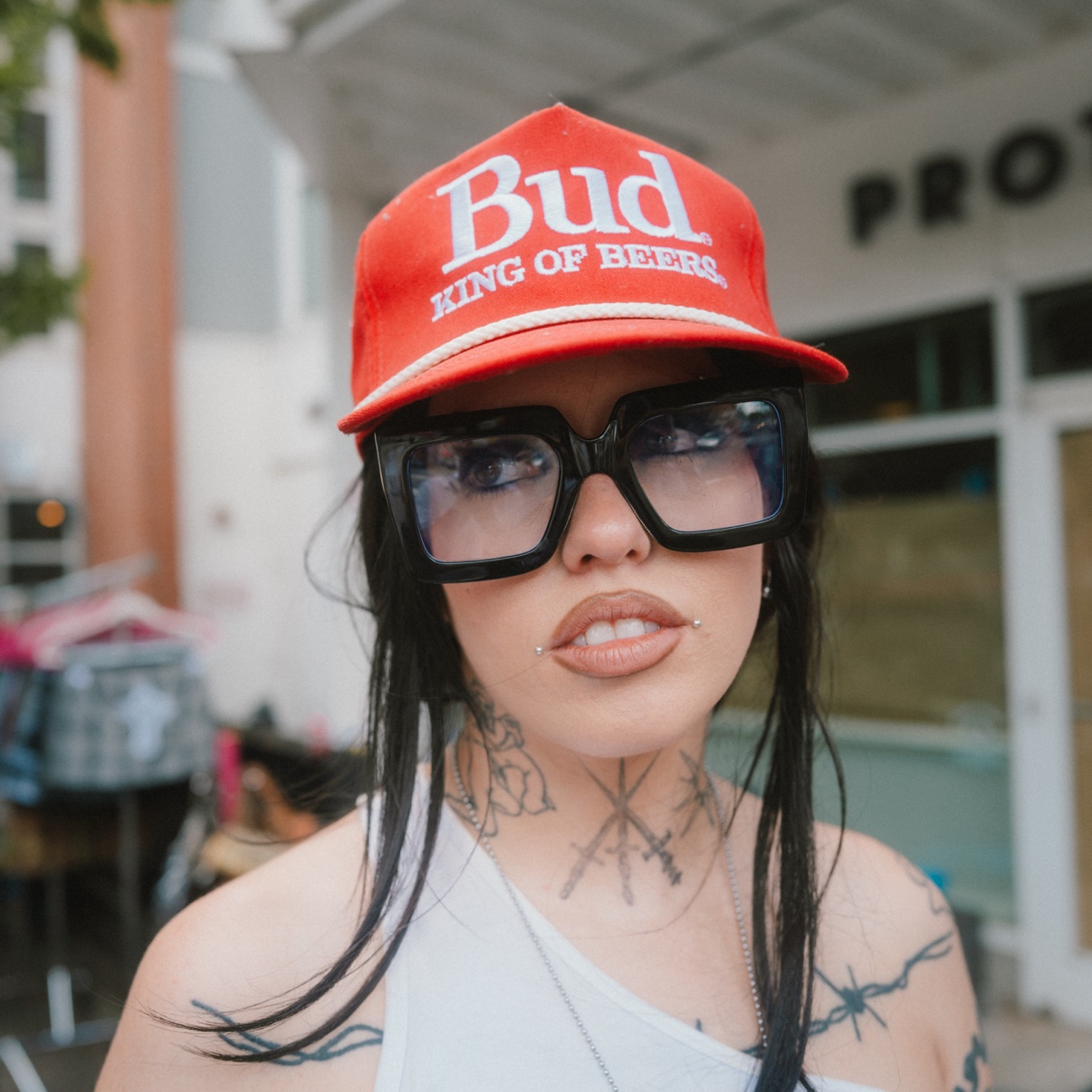 Street portrait, person in a red Bud cap and oversized glasses