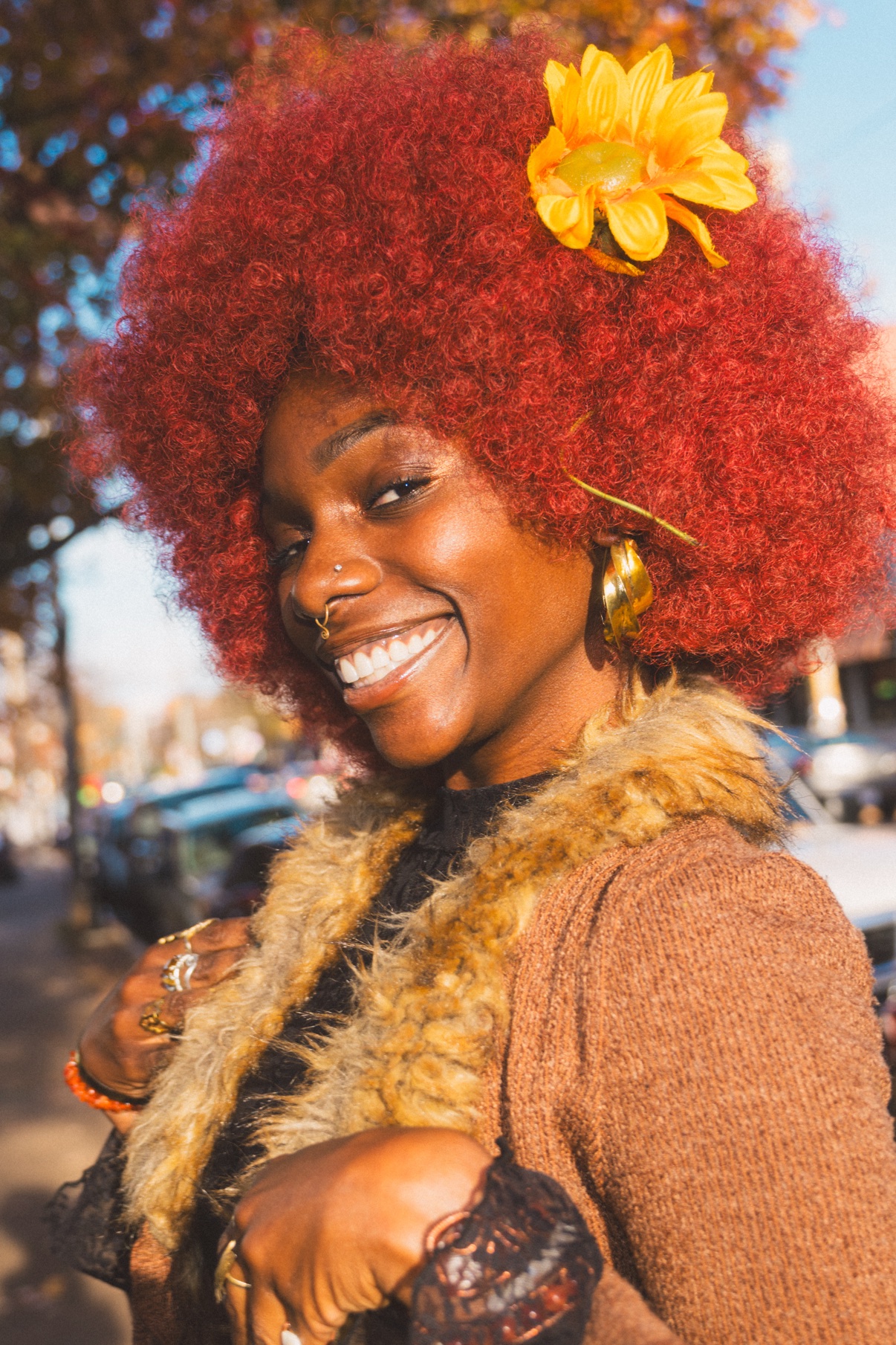 Street portrait, smiling person with red afro and sunflower